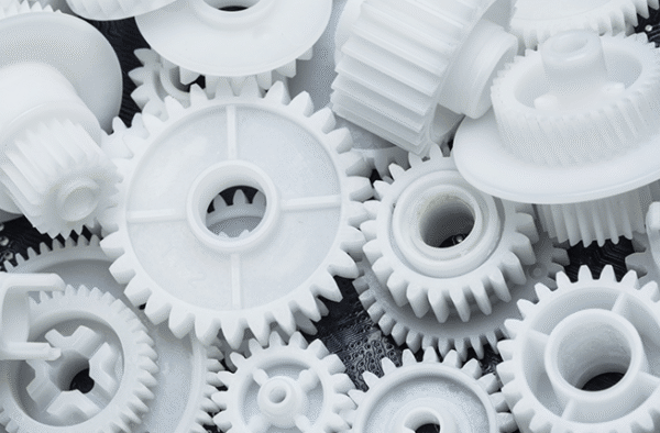Engrenagem técnica de Poliacetal (POM) utilizada em máquina industrial para substituição de peças metálicas.